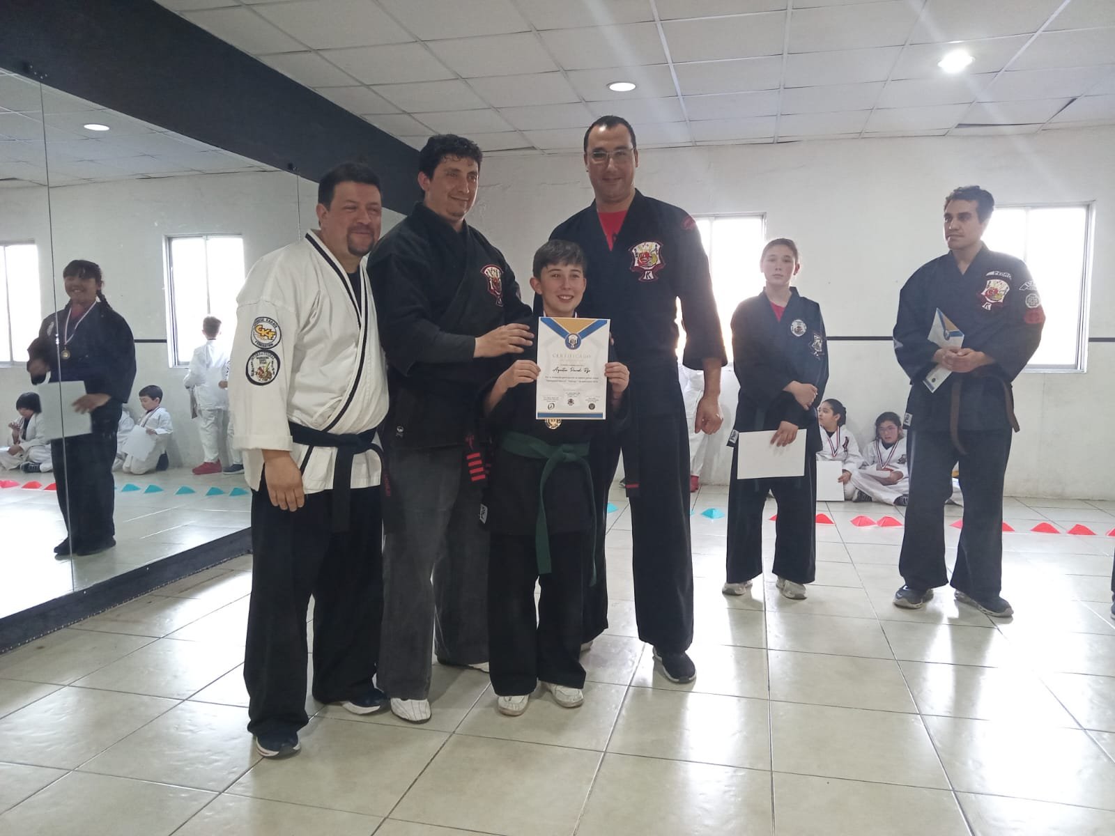 Entrega de certificado a un alumno junto a los instructores de la federación